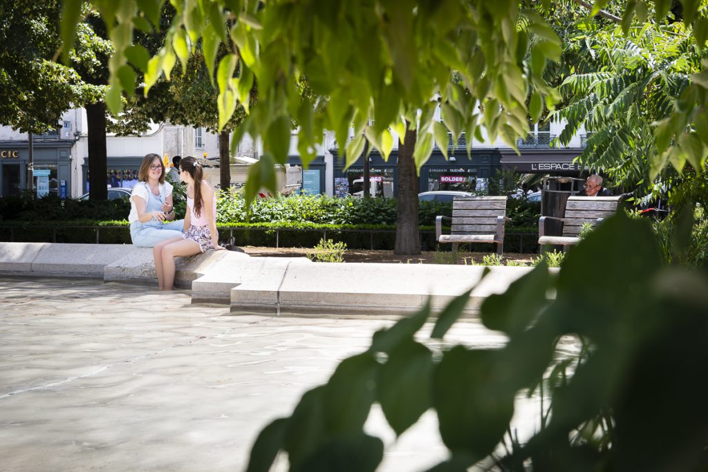 Une place à Lyon avec des espaces ombragés procurés par les arbres