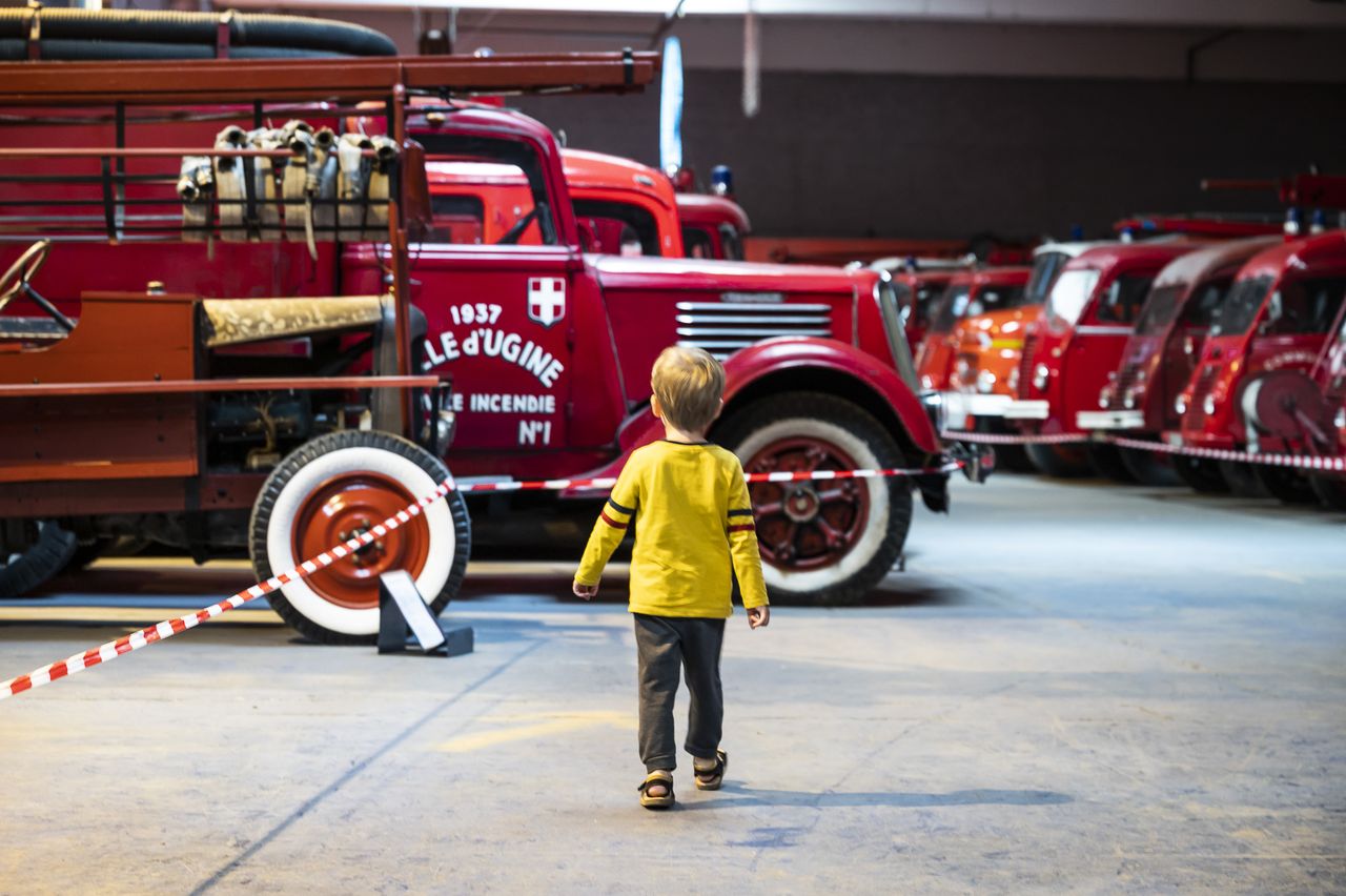 un enfant s'approche d'un ancien camion de pompiers